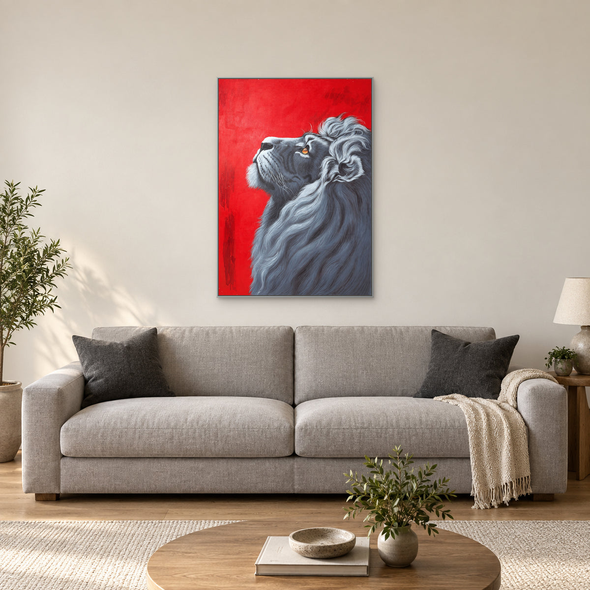 Lion wall art in a silver-tone frame centred above a pale grey sofa on an ivory wall