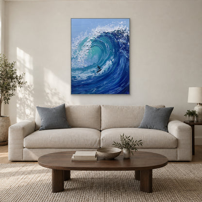 Silver-tone framed blue wave painting above a cream sofa with blue-grey cushions and an oval coffee table