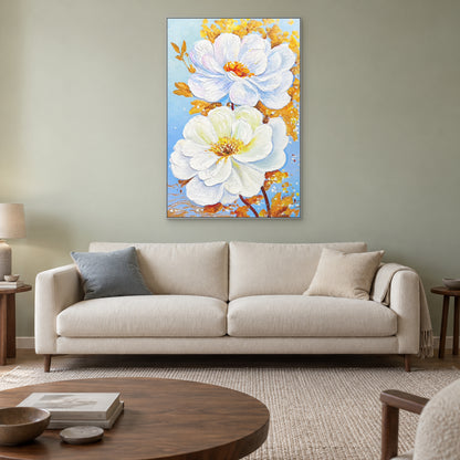 Vertical white and gold floral painting in a silver-coloured floating frame above a cream sofa on a muted green wall.