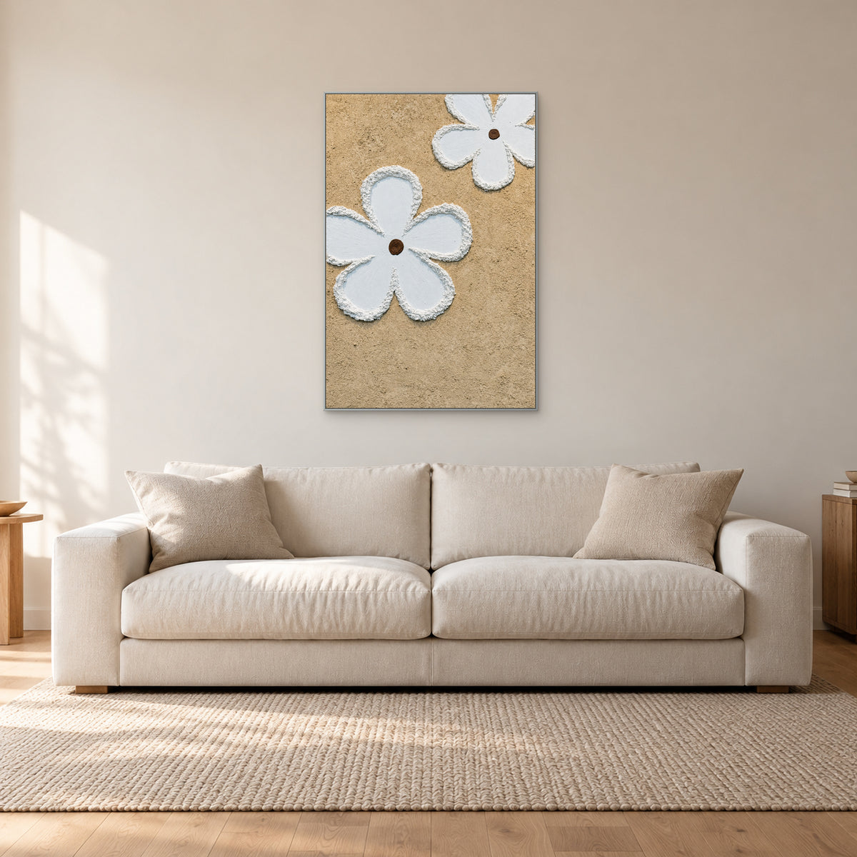 Vertical white flower relief in a slim silver-coloured frame above an off-white sofa