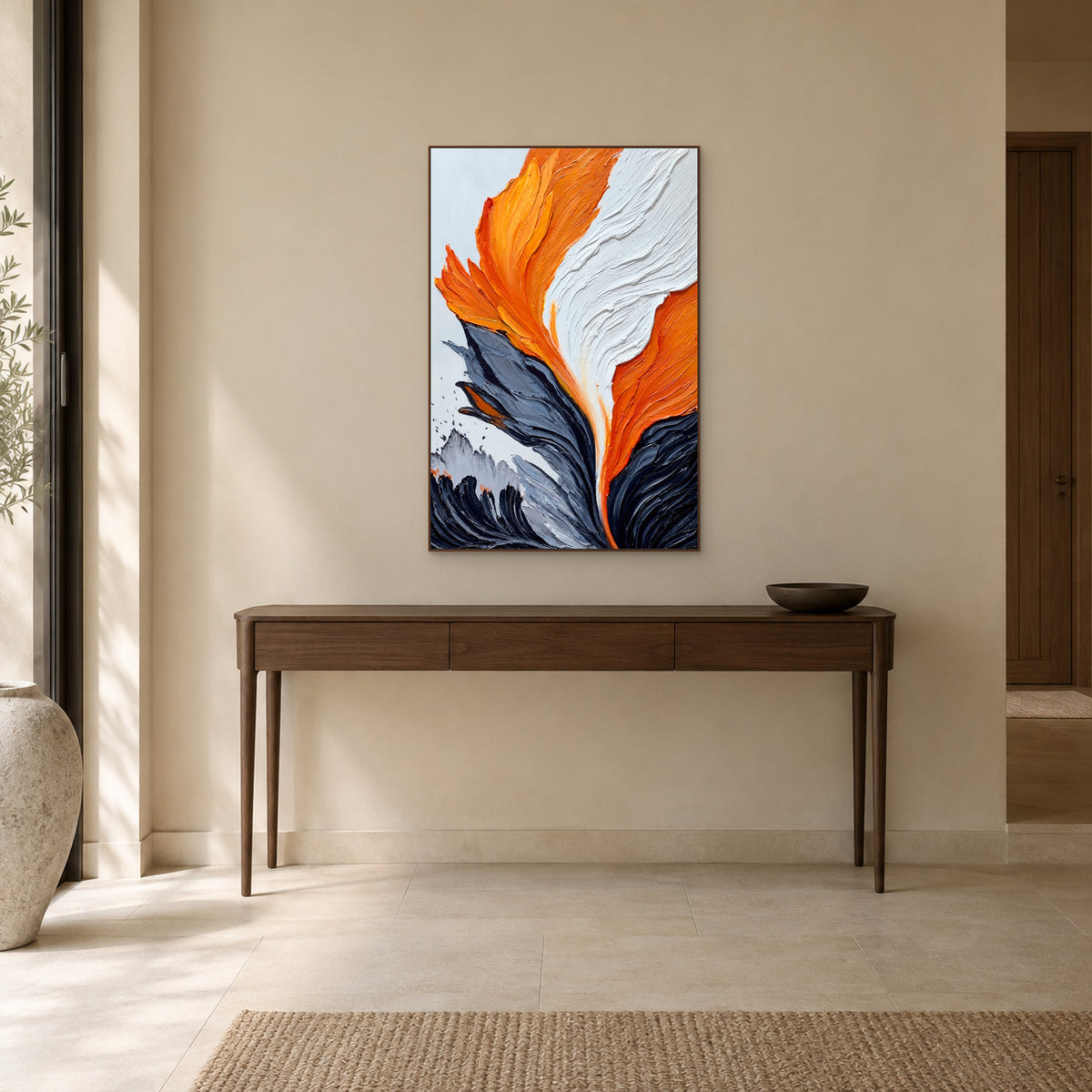 Tableau abstrait orange dans un cadre flottant ton noyer, au-dessus d’une console d’entrée en bois