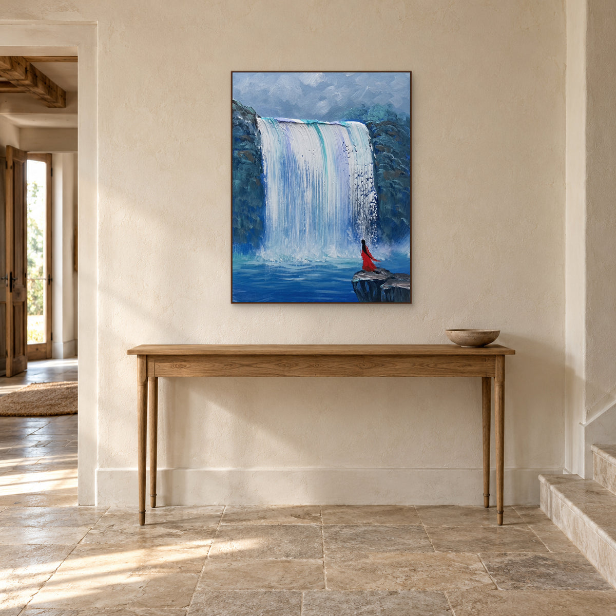 Waterfall landscape in a walnut frame centred above an oak entryway console, with a shallow bowl to the right.