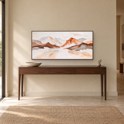 Panoramic mountain painting in a walnut-tone floating frame centred above a wooden entryway console