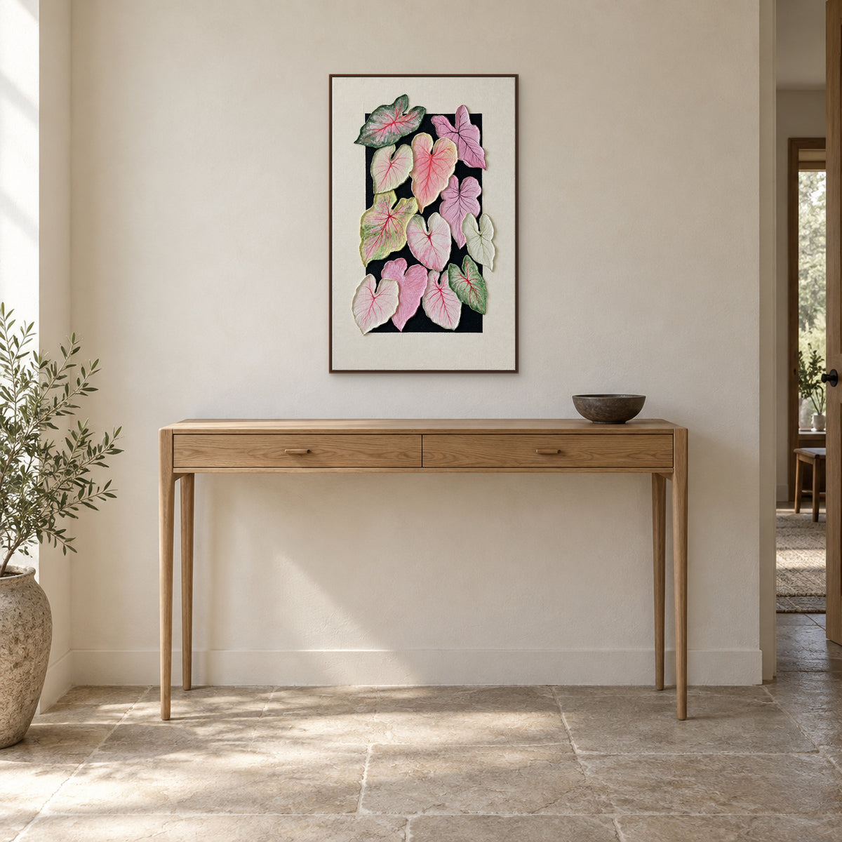 Tableau vertical de caladium dans un cadre flottant ton noyer, au-dessus d’une console d’entrée en chêne clair