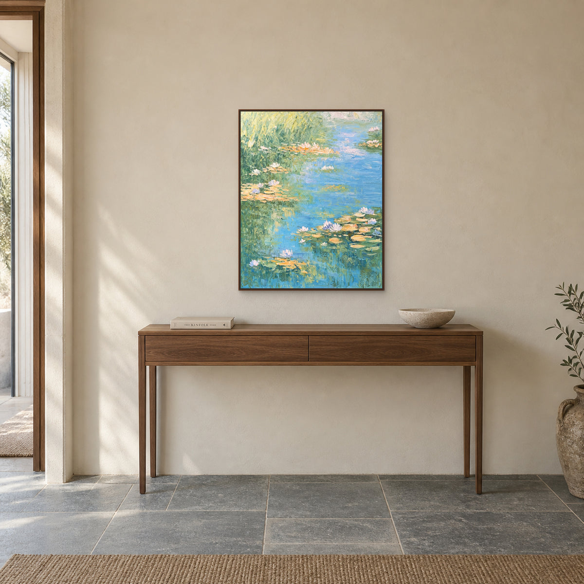 Water-lily pond painting in a walnut-look floating frame above a slim entryway console
