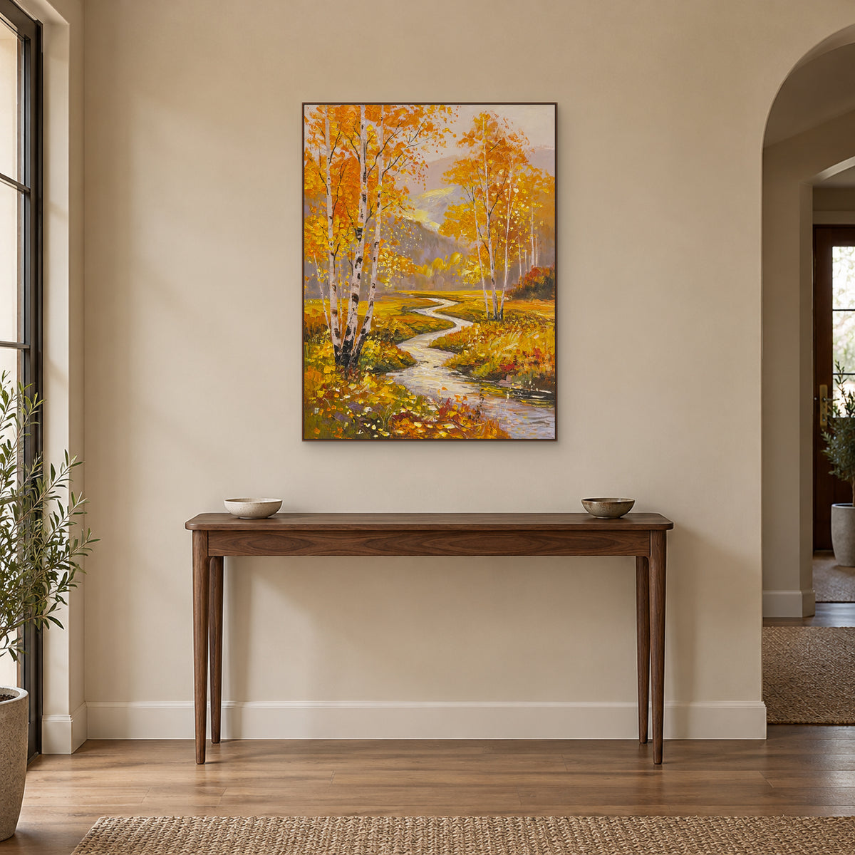 Golden birch stream artwork in a walnut-toned frame above a wooden entryway console