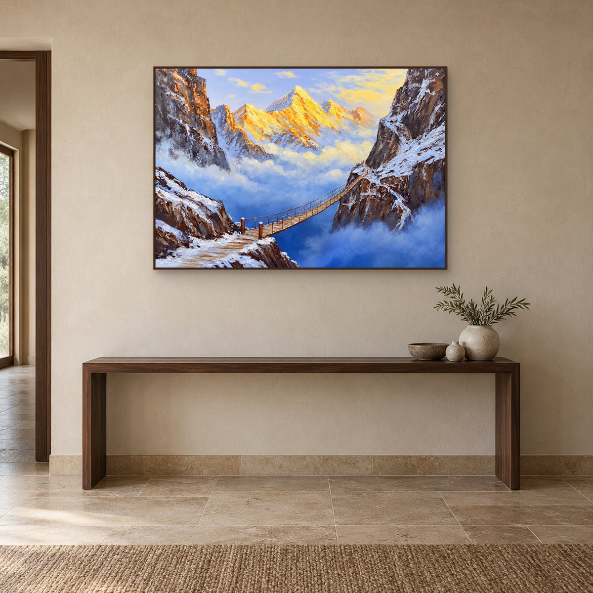 Golden snow peaks and a wooden bridge in a walnut-tone frame above an entryway console