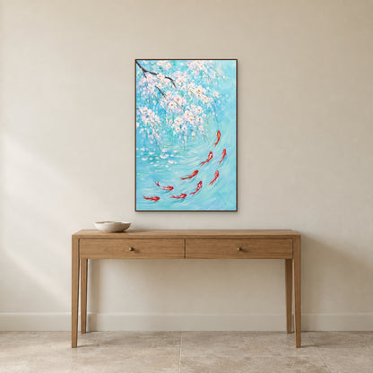 Koi and white blossom painting in a walnut-coloured floating frame centred above a slender oak console on an ivory wall.
