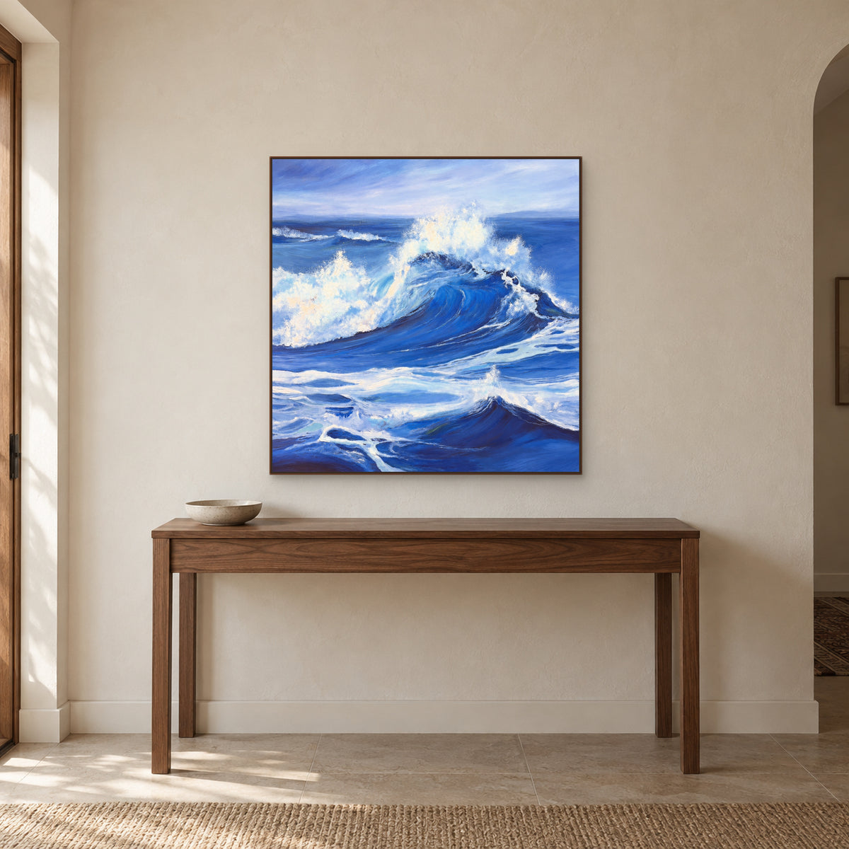 Near-square blue wave artwork in a walnut-toned frame above a simple entryway console