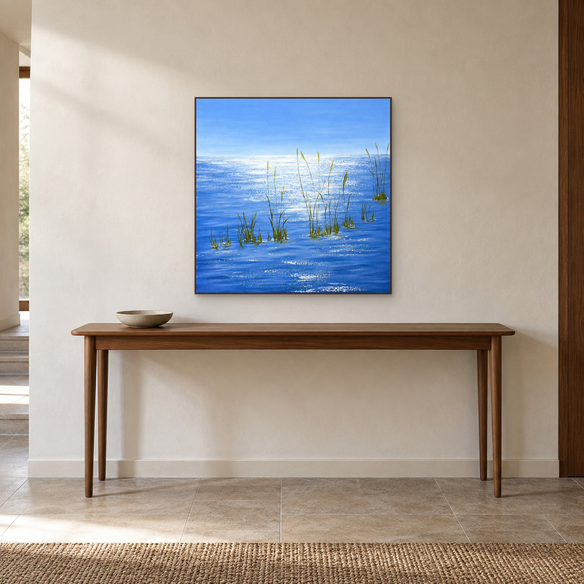 Lueurs sur l’eau bleue dans un cadre aspect noyer au-dessus d’une fine console d’entrée