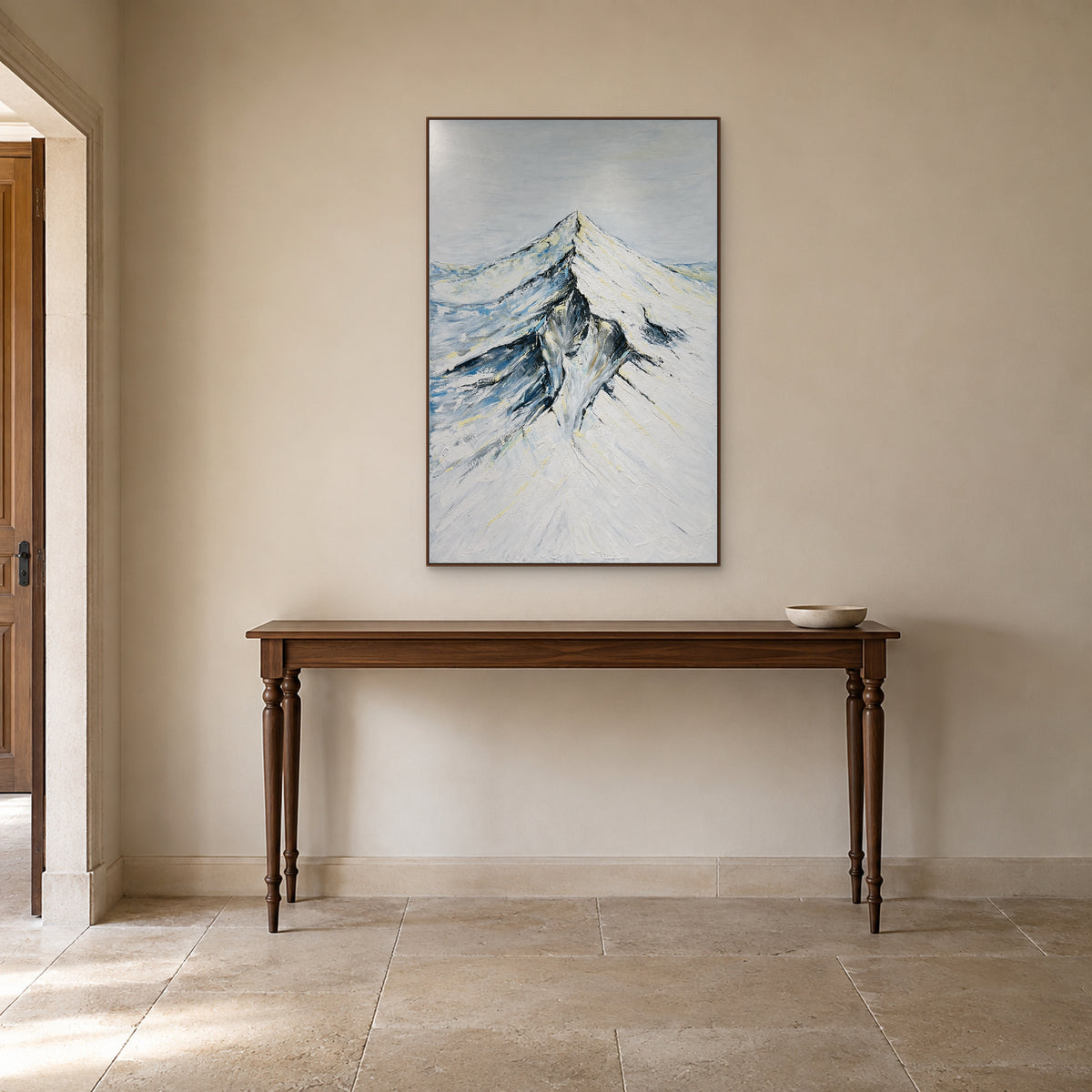 Portrait snowy mountain painting in a walnut-tone frame above an entryway console