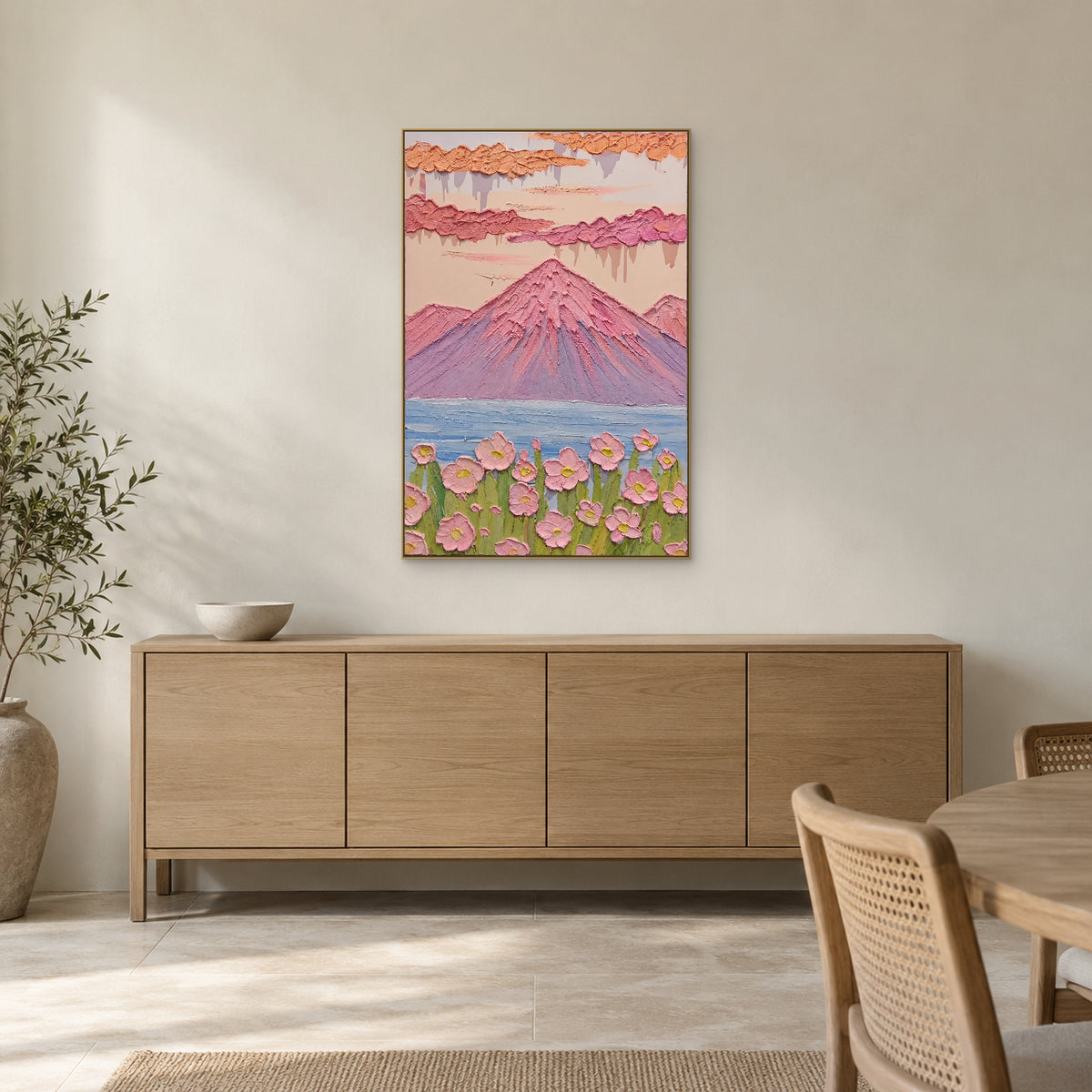 Tableau de montagne rose et lac bleu dans un cadre champagne au-dessus d’un buffet de salle à manger en bois clair