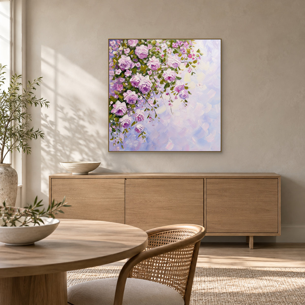Champagne-framed lilac rose painting above an oak sideboard in a sunlit dining space