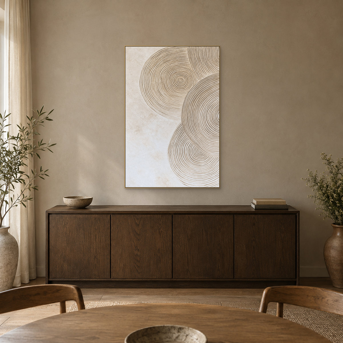 Hand-textured circle artwork in a champagne-tone frame above a dark wooden dining-room sideboard.