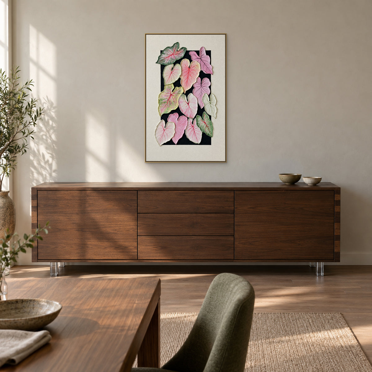 Tableau de feuilles de caladium dans un cadre flottant champagne, au-dessus d’un buffet en chêne fumé dans une salle à manger
