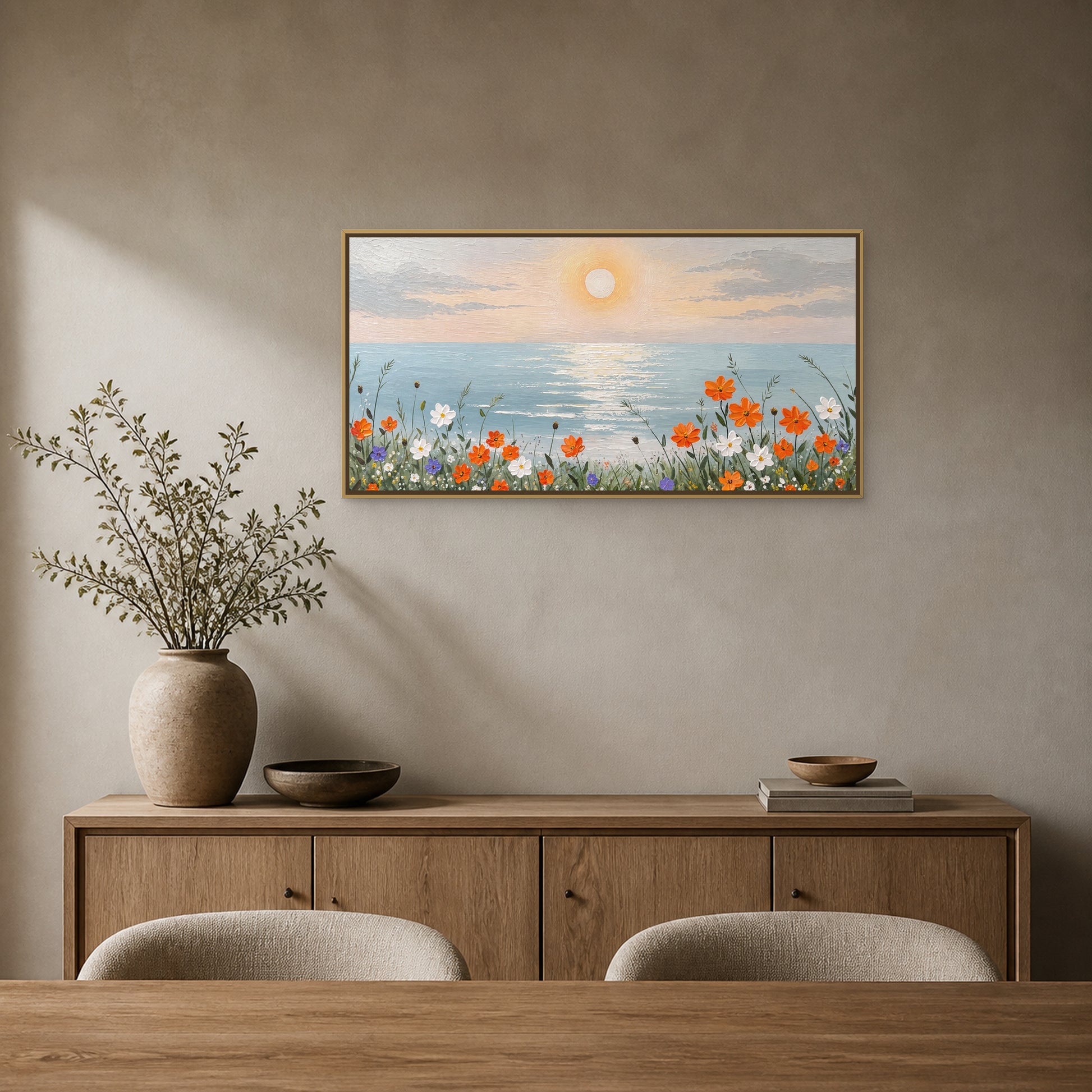 Fleurs du rivage au lever du soleil dans un fin cadre flottant champagne au-dessus d’un buffet en chêne dans une salle à manger gris sable