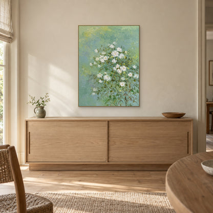 Tableau floral de jasmin dans un cadre champagne, centré au-dessus d’un buffet en bois clair