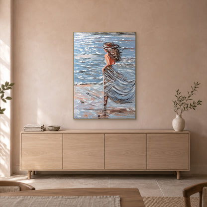 Femme au bord de mer dans un cadre flottant champagne, au-dessus d'un buffet ton chêne clair devant un mur beige rosé