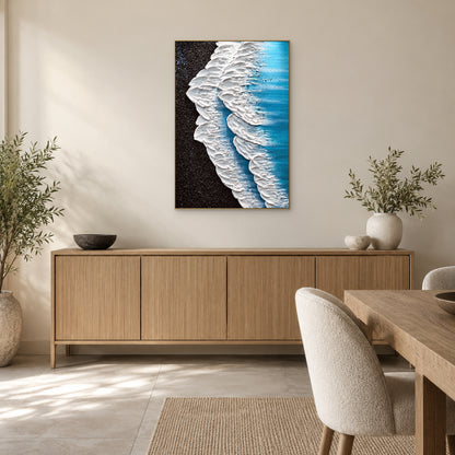 Vertical wave painting in a champagne-tone frame above a wooden sideboard beside a dining table