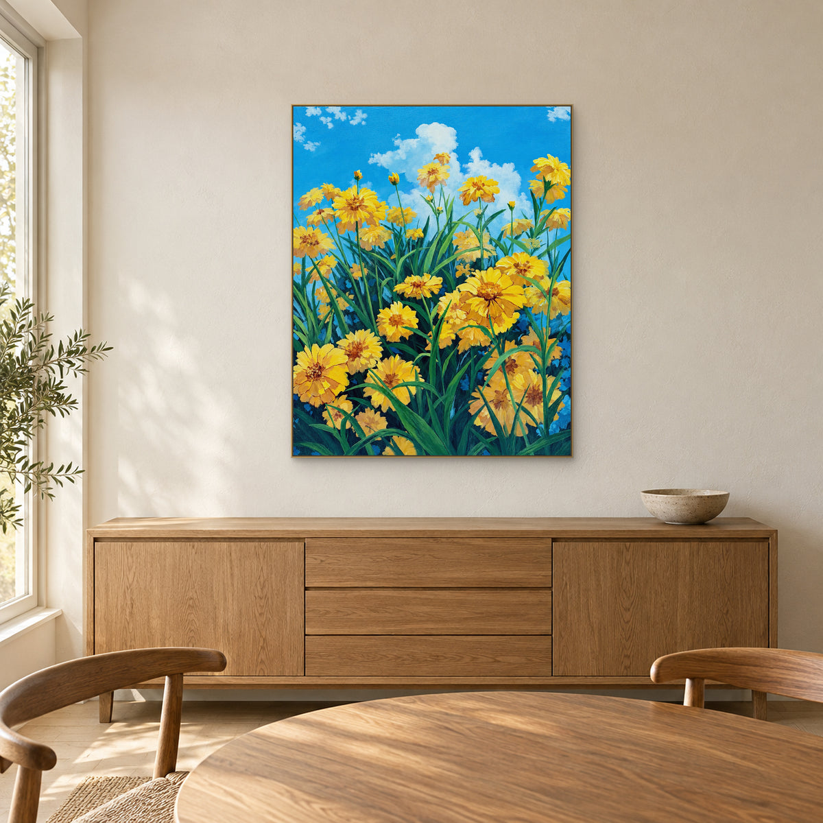 Yellow flowers and blue sky in a champagne-tone frame above a dining-room sideboard