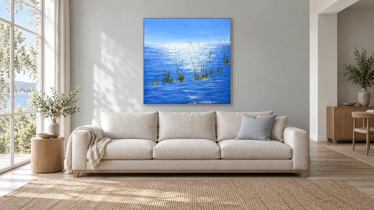 Silver Light on Blue Water dans un cadre argenté fin, au-dessus d’un canapé ivoire dans un intérieur lumineux
