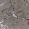 Shaping a blue wave with a palette knife, accompanied by soft solo piano.
