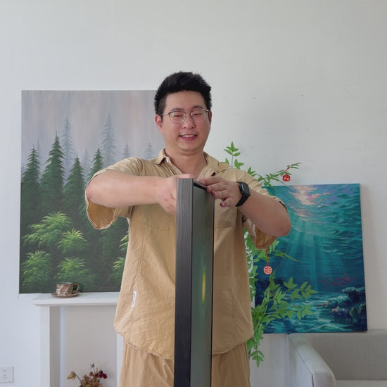 Studio video of a green moon and leafy branches painting turning from side view to full front