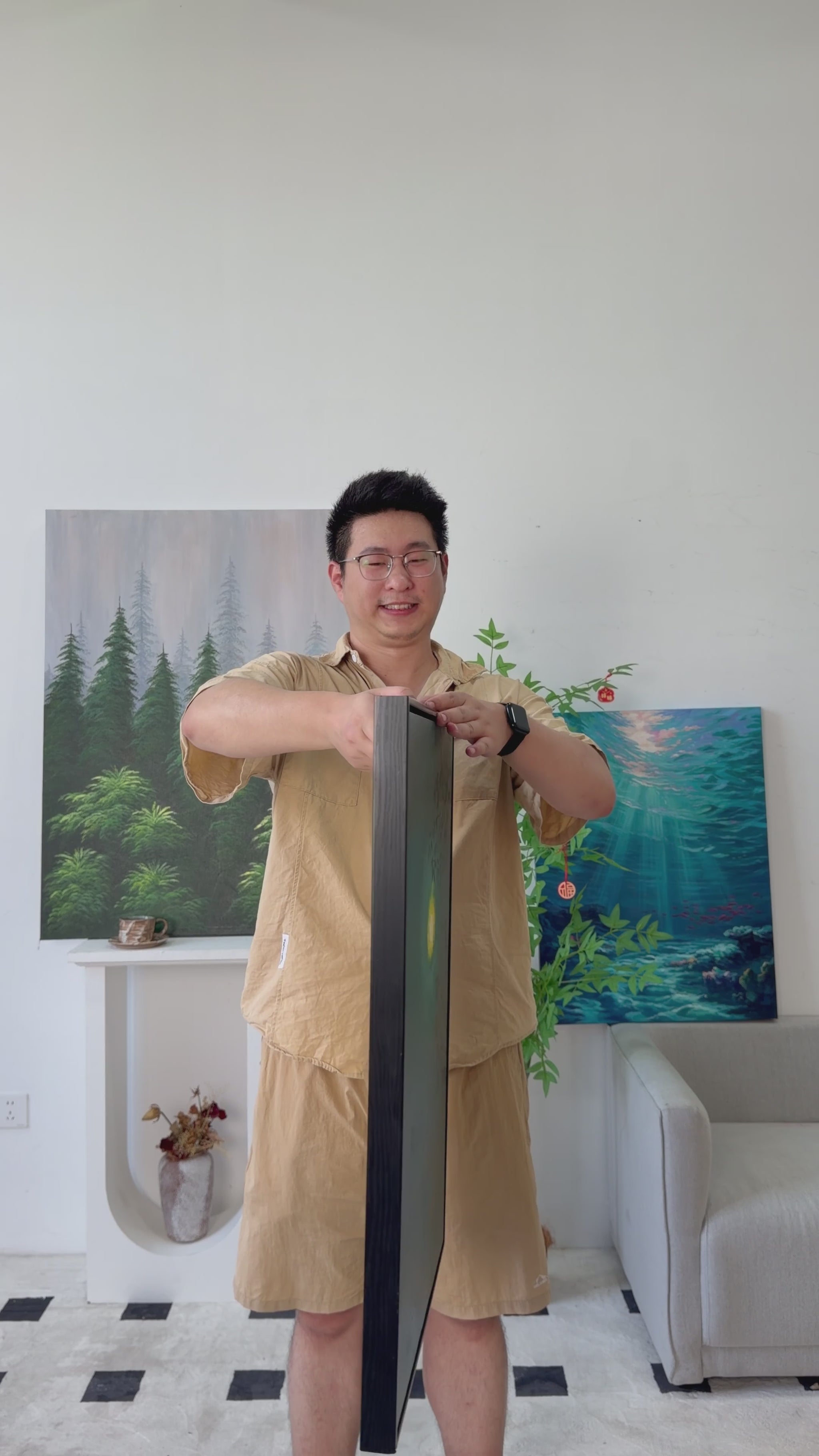 Studio video of a green moon and leafy branches painting turning from side view to full front