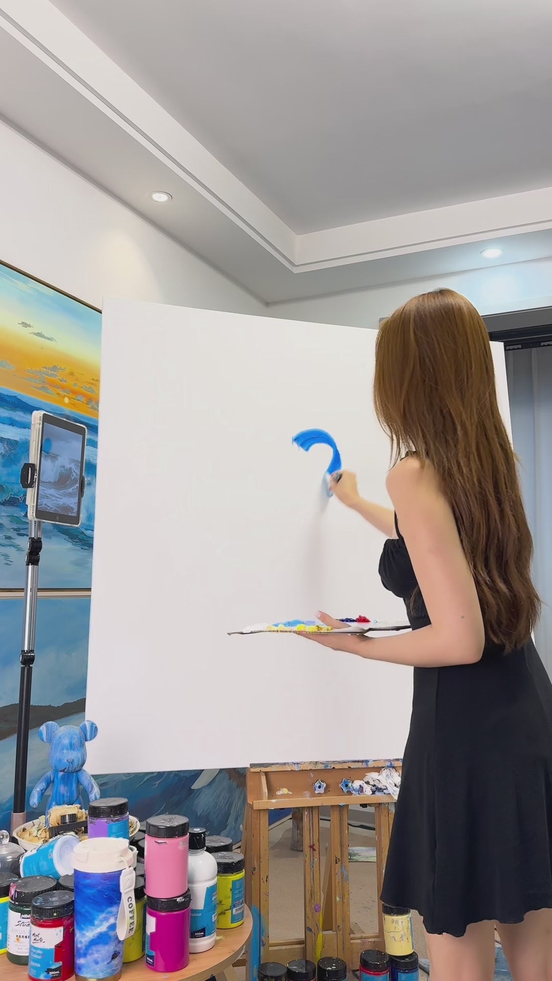 Painting a blue wave from its first curved strokes to the finished white spray and sea foam