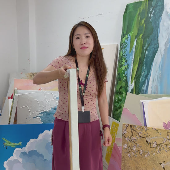 A yellow blossom painting turned towards the camera, followed by a gold-framed view on an ivory wall