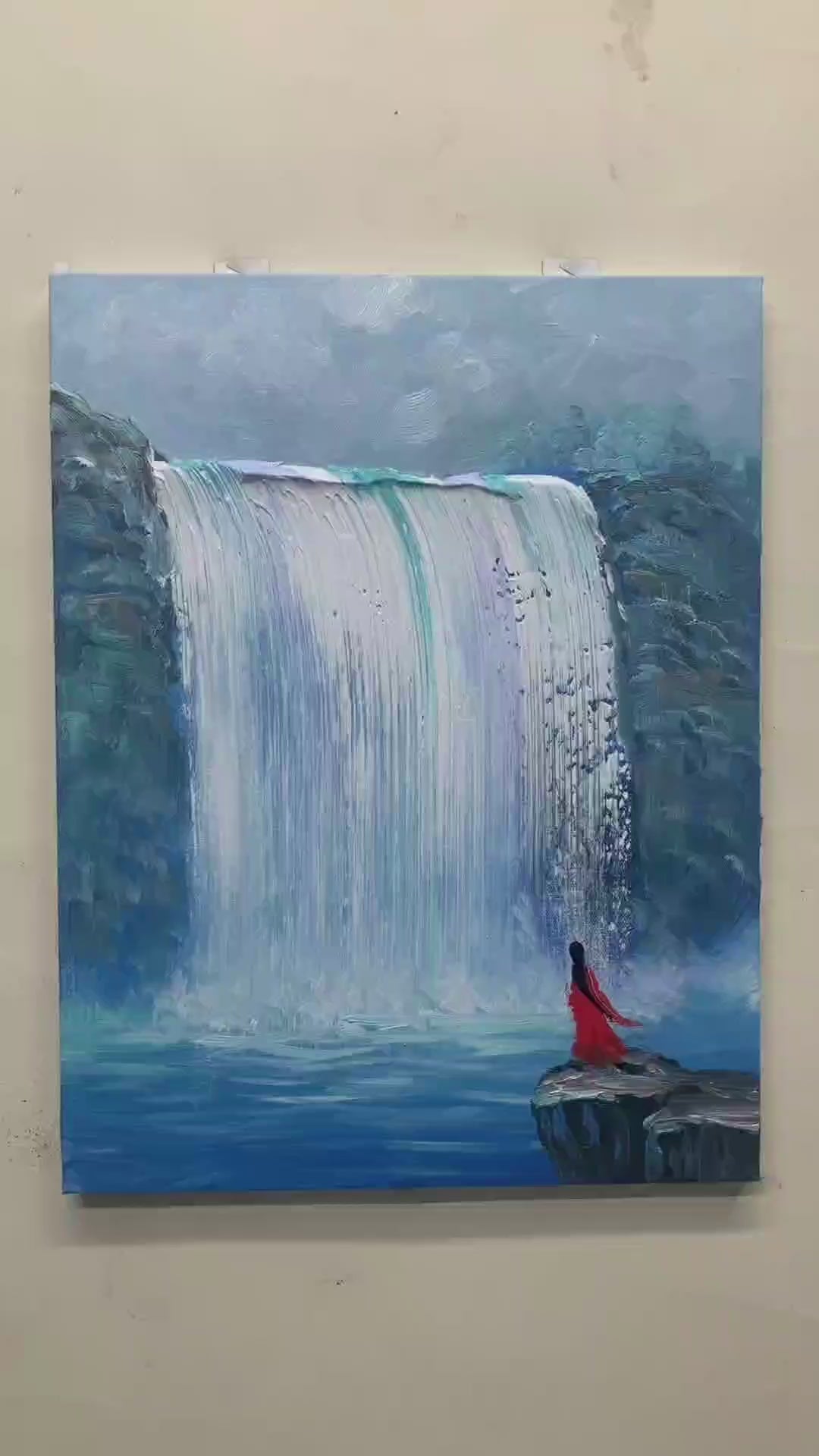 Painting a blue waterfall with broad tools, adding rocky cliffs and a small figure in red, followed by the finished artwork.