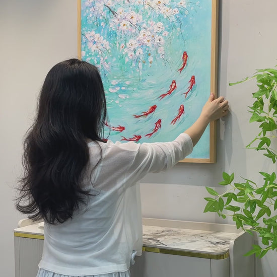 Framing and handling of the koi painting, a close view of raised white blossoms, a hand tracing the koi and a finished wall display.